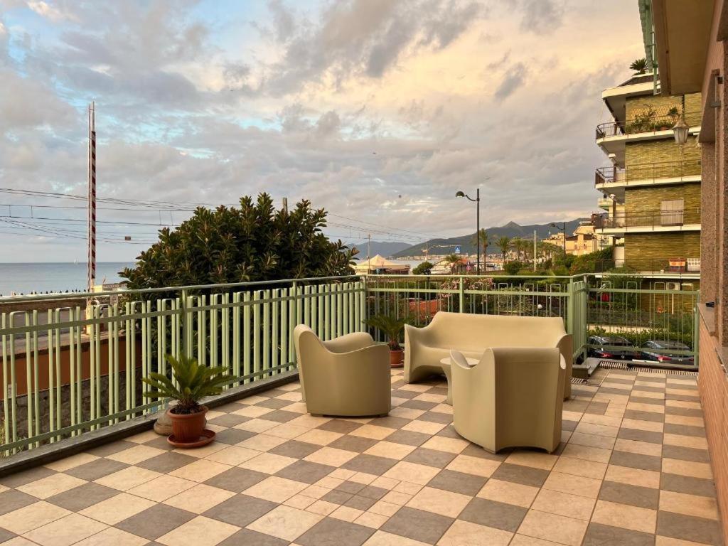 un balcon avec des chaises blanches et un balcon avec l'océan dans l'établissement Albergo Regina Mundi, à Pietra Ligure