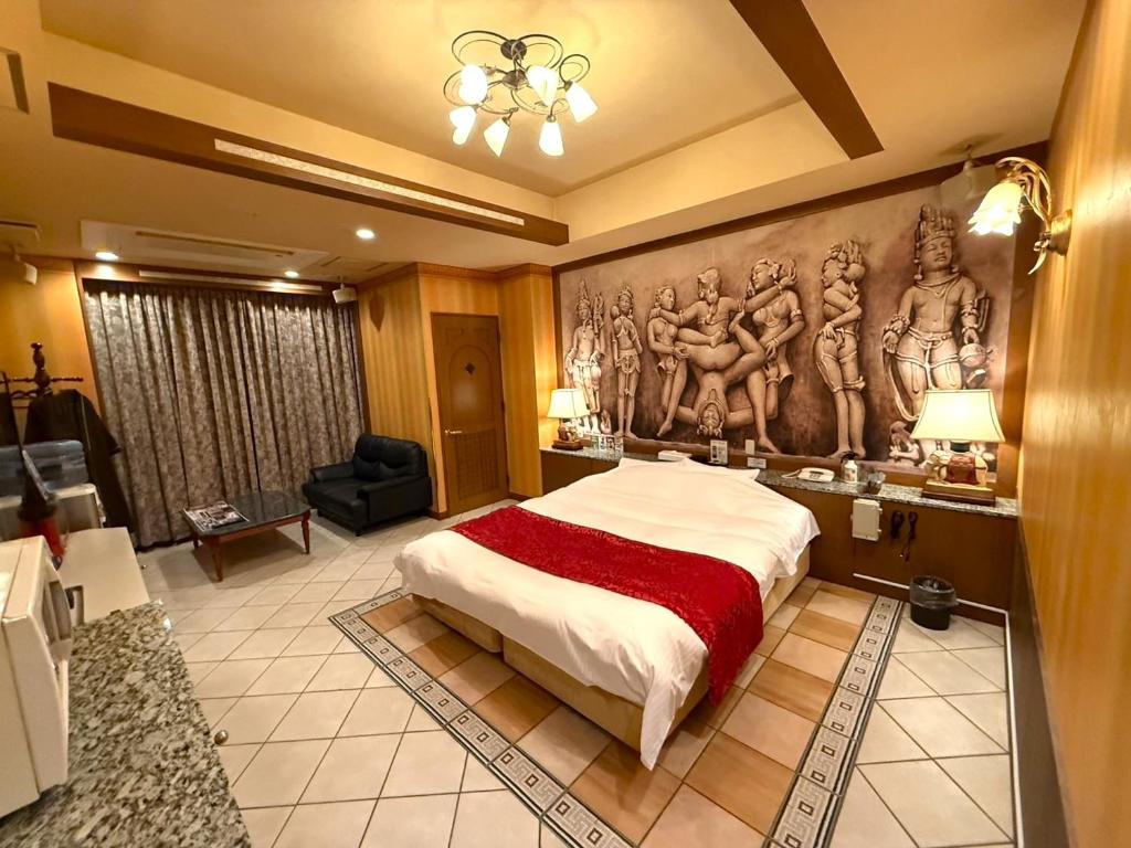 une chambre avec un grand lit avec un tableau au mur dans l'établissement ホテルメイフェア Adult Only 男塾ホテルグループ, à Yōkaichi