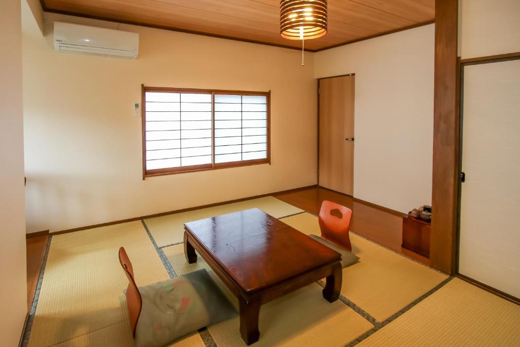 un salon avec une table et des chaises dans l'établissement 別府鉄輪温泉 萬力屋manrikiya, à Beppu