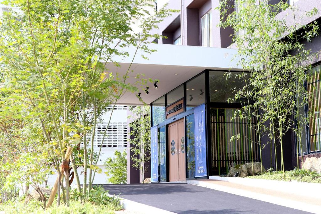 une vue extérieure d'un bâtiment avec des arbres dans l'établissement Ooedo Onsen Monogatari Beppu Seifu, à Beppu