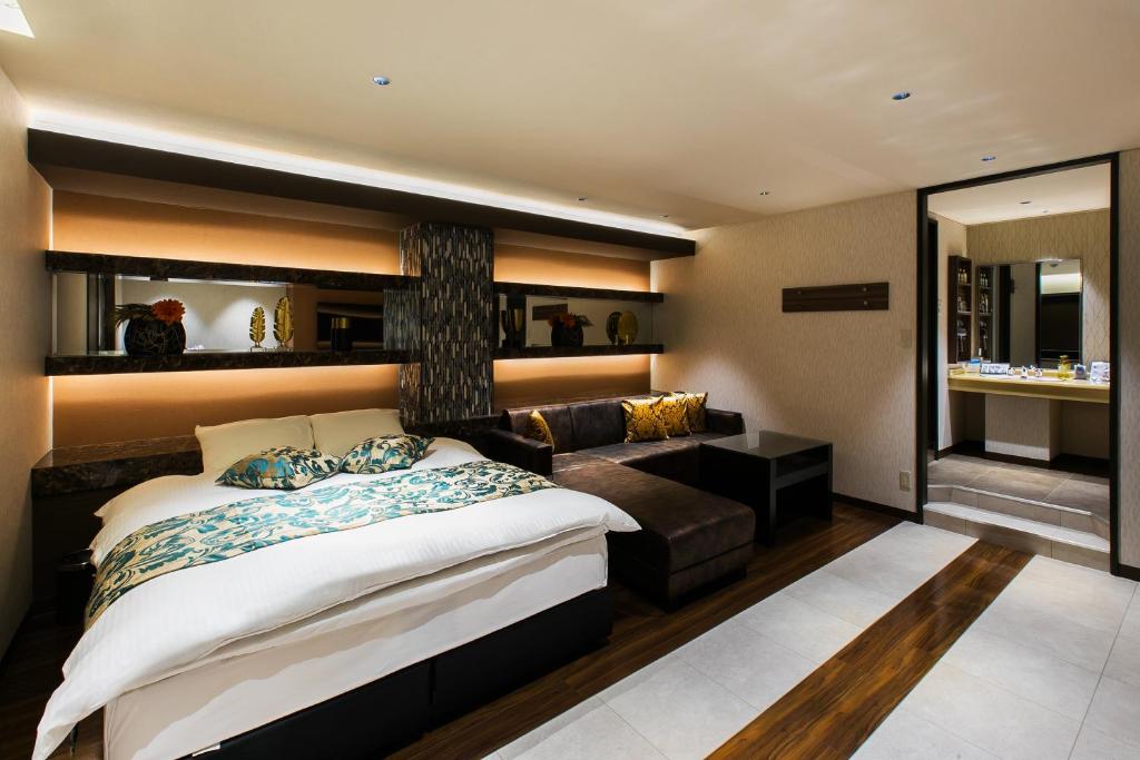 une chambre avec un lit et un canapé dans l'établissement HOTEL Luana, à Kitakyūshū