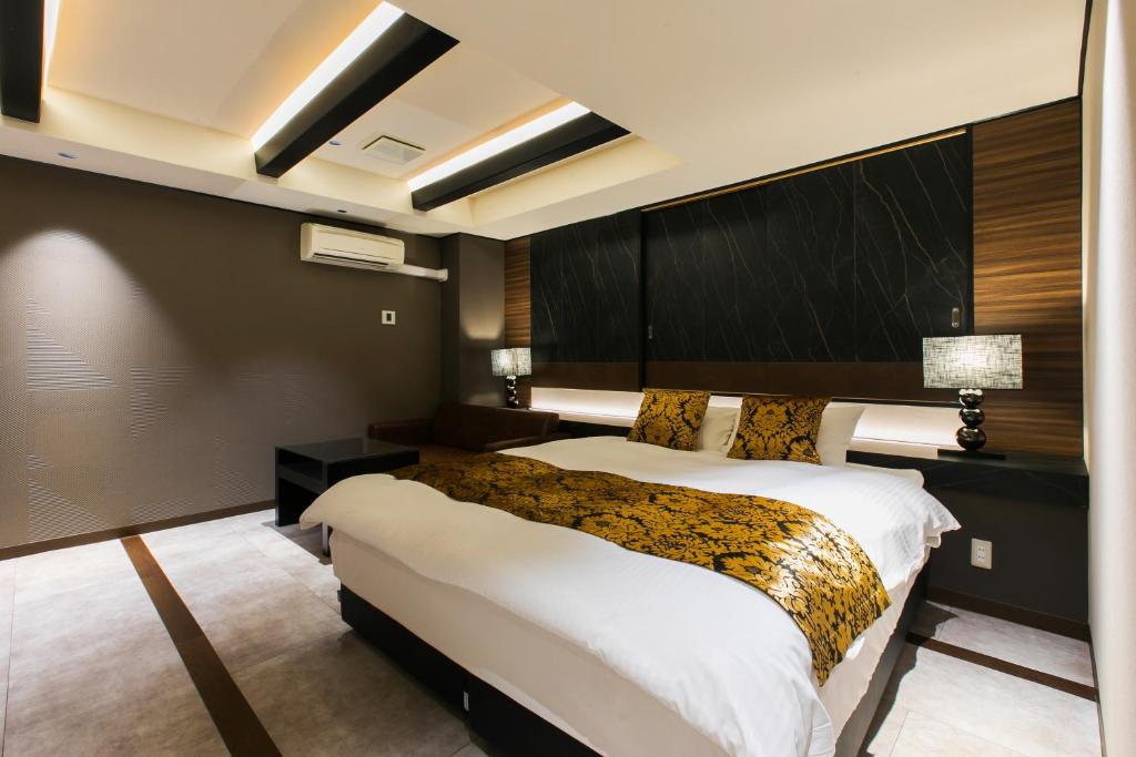 une chambre avec un grand lit dans une pièce dans l'établissement HOTEL Luana, à Kitakyūshū