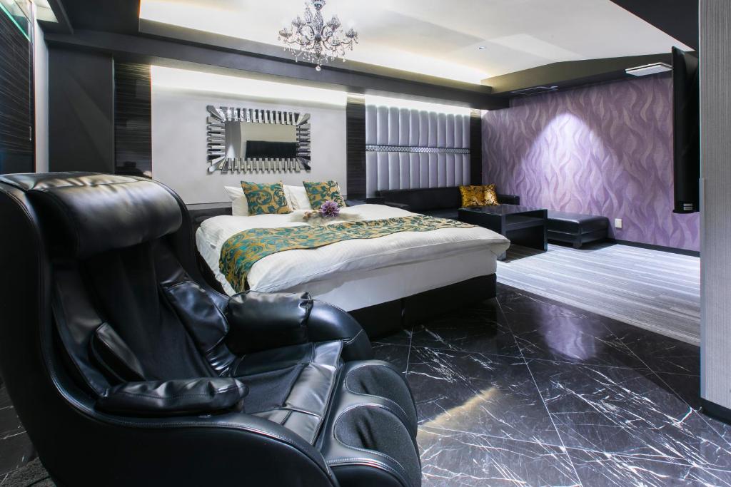 - une chambre avec un lit king-size et une chaise dans l'établissement HOTEL Luana, à Kitakyūshū 2 autres photos