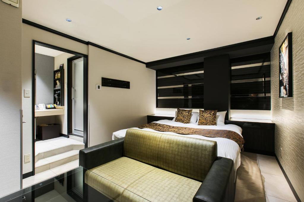 une chambre avec un lit et un canapé dans l'établissement HOTEL Luana, à Kitakyūshū