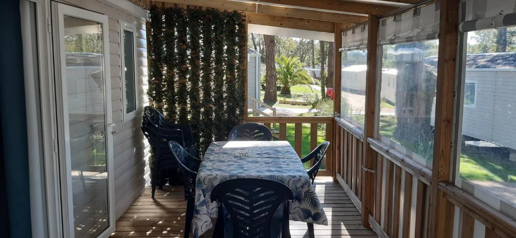 une terrasse couverte avec une table et des chaises. dans l'établissement mobil home Piriac 2 chambres 4 à 6 pers, à Piriac-sur-Mer