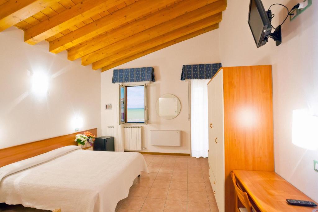 une chambre avec un lit et une fenêtre dans l'établissement Hotel Ca' D'Oro, à Caorle