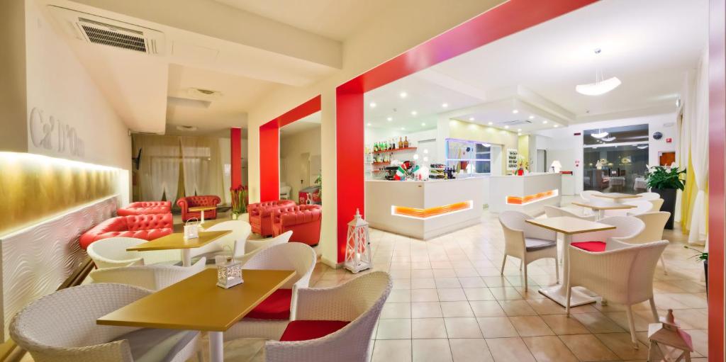 un restaurant avec des tables et des chaises dans une salle dans l'établissement Hotel Ca' D'Oro, à Caorle