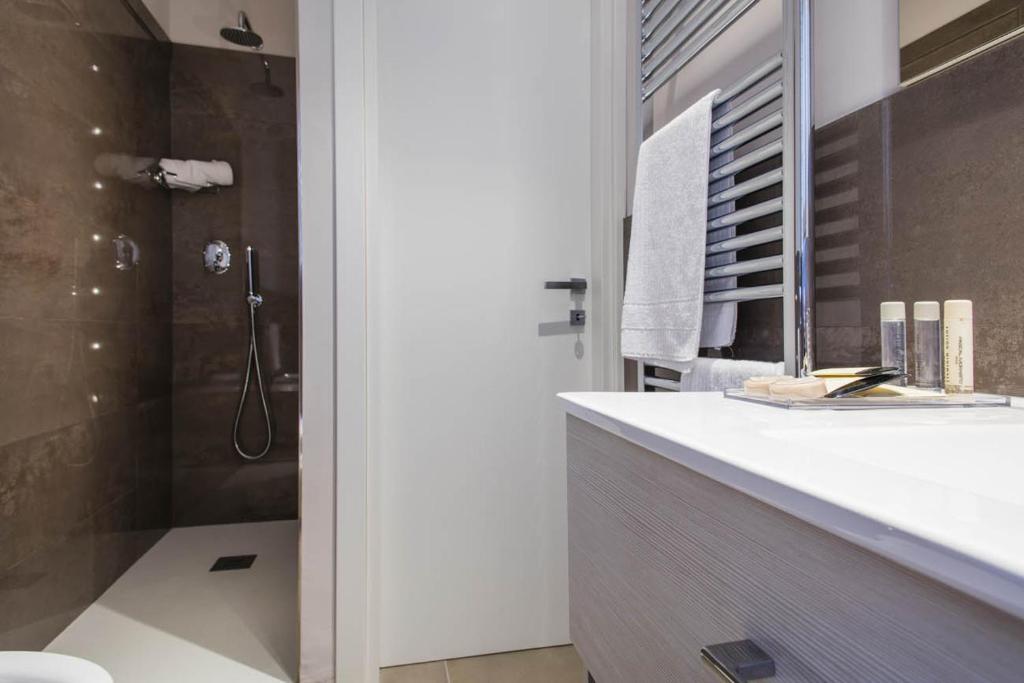 une salle de bain avec douche, lavabo et toilettes dans l'établissement Manè Boutique Hotel, à Roseto degli Abruzzi