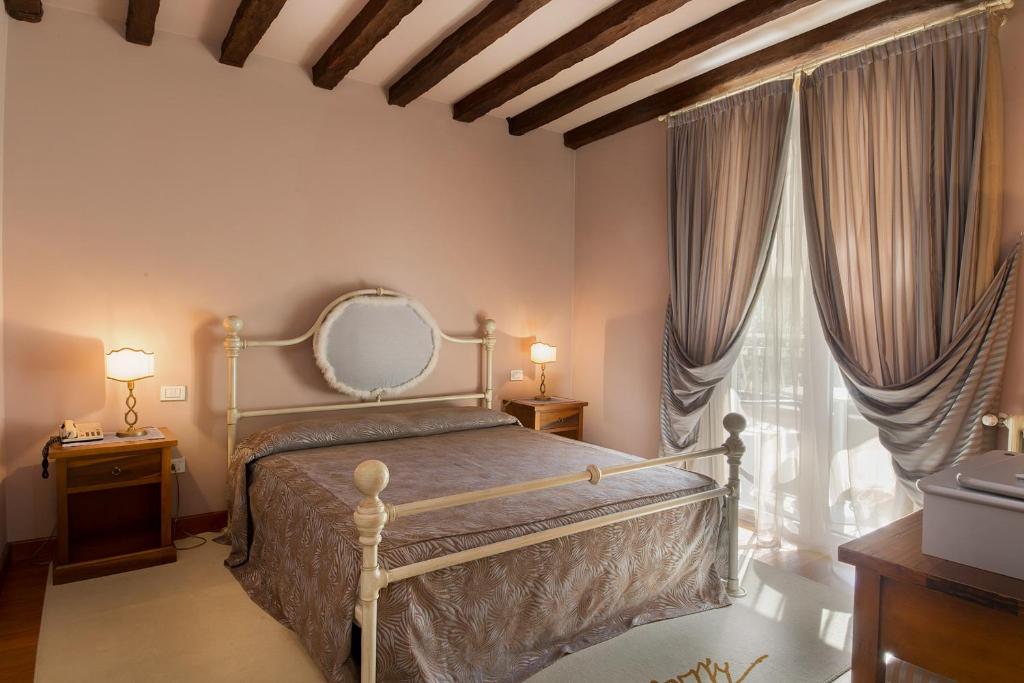 une chambre avec un lit et une grande fenêtre dans l'établissement Hotel Serenella, à Sirmione 94 autres photos