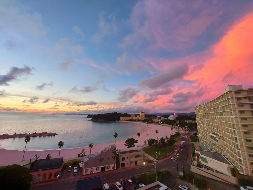 - une vue sur la plage au coucher du soleil depuis un bâtiment dans l'établissement Hotel Sanrakuso, à Shirahama
