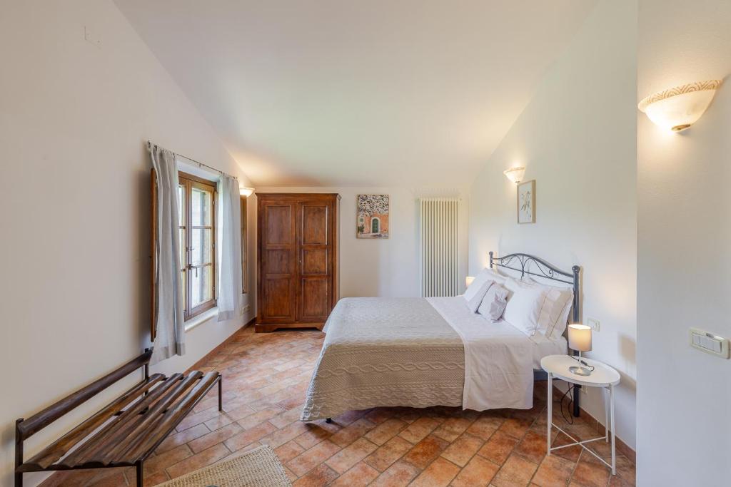 une chambre blanche avec un lit et une table dans l'établissement Casa Baiocco, à Città della Pieve