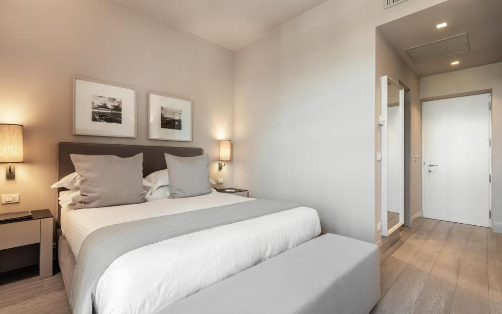 une chambre blanche avec un grand lit et une fenêtre dans l'établissement Villa Grey, à Forte dei Marmi 88 autres photos