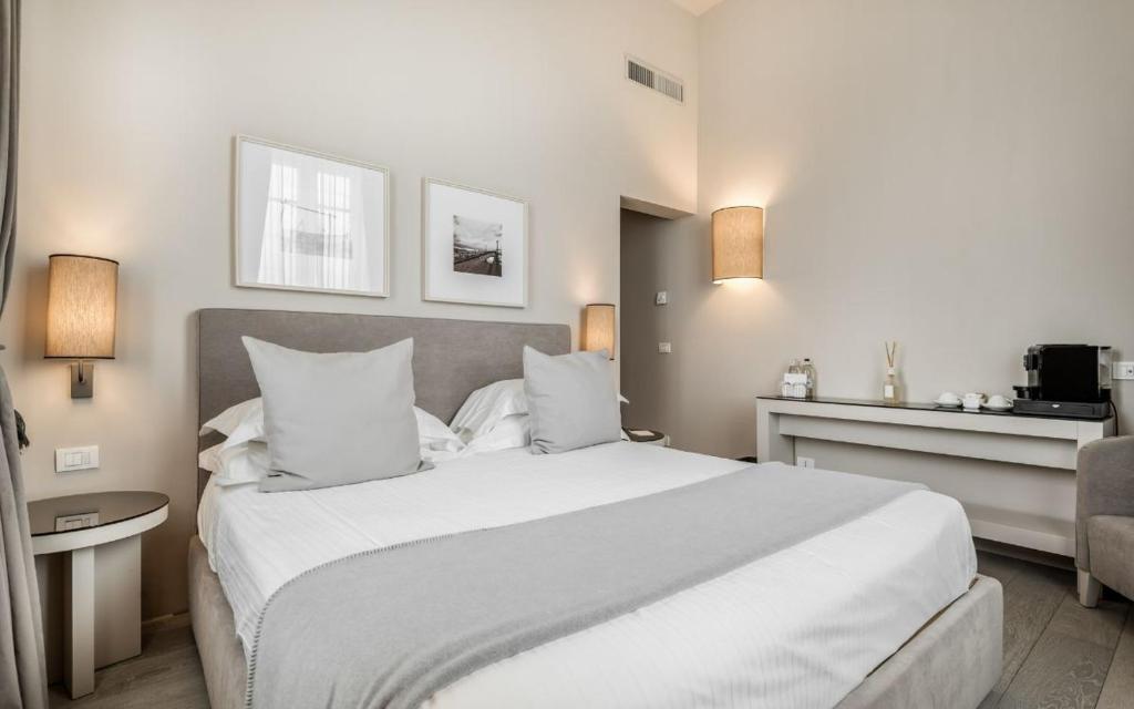 une chambre avec un grand lit blanc et une chaise dans l'établissement Villa Grey, à Forte dei Marmi