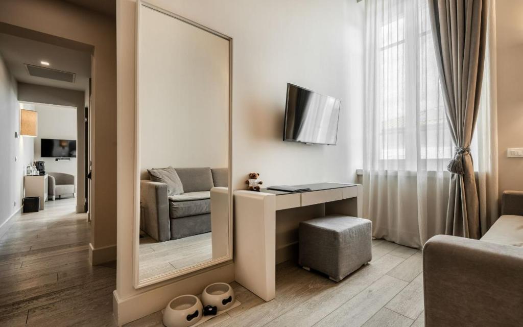 Cette chambre comprend un miroir, une chaise et un canapé. dans l'établissement Villa Grey, à Forte dei Marmi