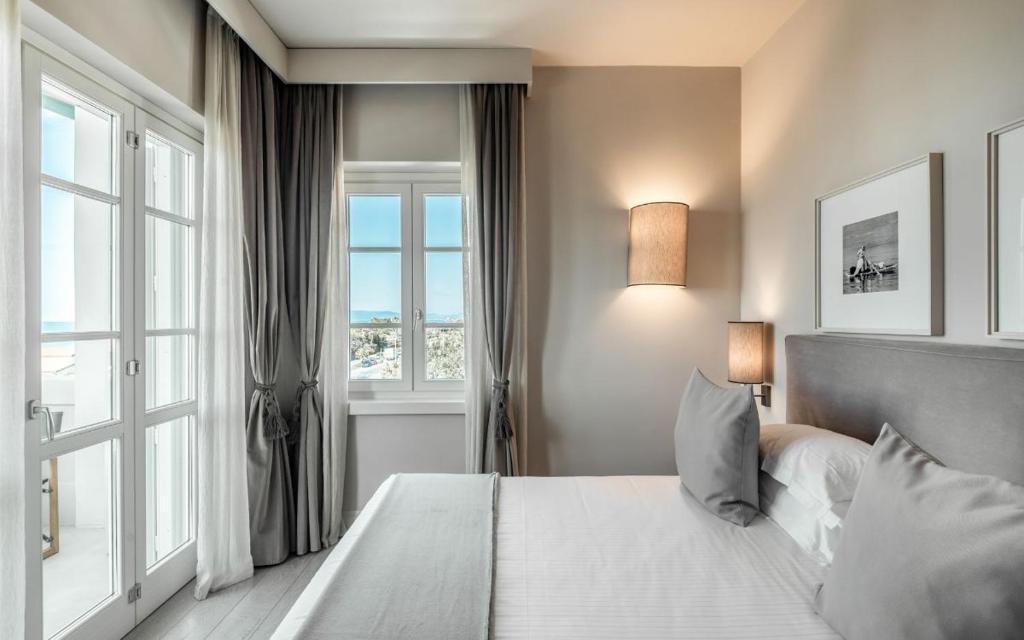 une chambre avec un lit et une grande fenêtre dans l'établissement Villa Grey, à Forte dei Marmi