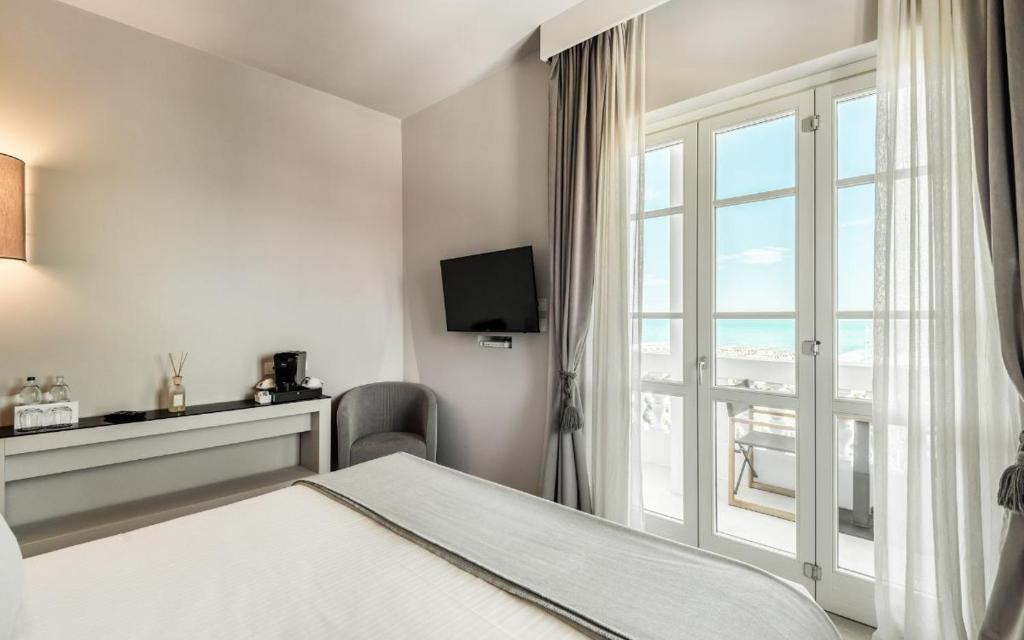 une chambre d'hôtel avec un lit et une fenêtre dans l'établissement Villa Grey, à Forte dei Marmi