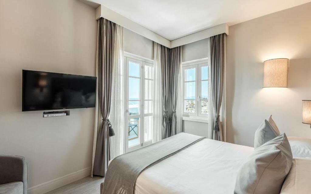 une chambre avec un lit et une télévision sur un mur dans l'établissement Villa Grey, à Forte dei Marmi