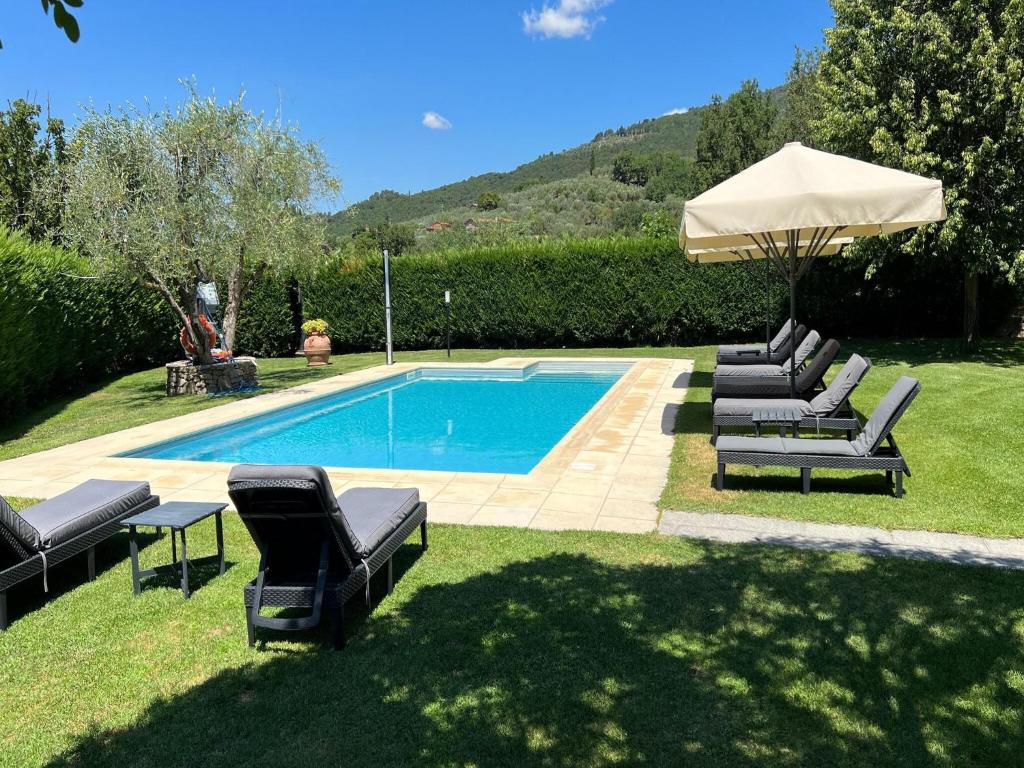 une piscine avec des chaises longues et un parasol dans l'établissement Villa in Tuscany with Private Pool & Views, à Loro Ciuffenna