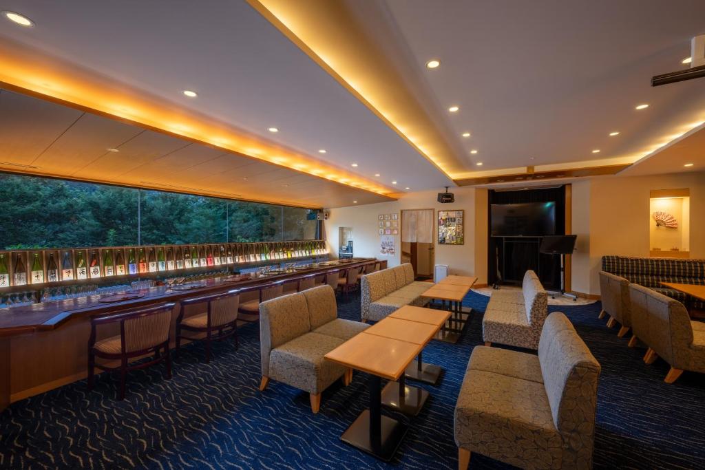 un restaurant avec des tables et des chaises et un bar dans l'établissement Iizaka Onsen Surikamitei Ohtori, à Fukushima