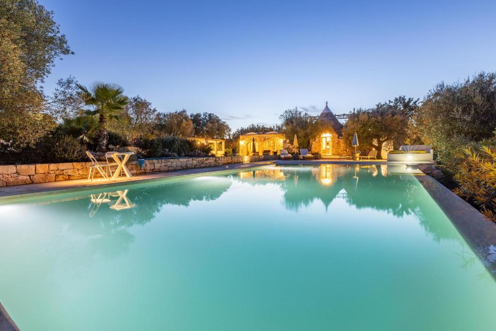 une grande piscine dans une arrière-cour avec une maison dans l'établissement Sentiero della Valle, à Ceglie Messapica