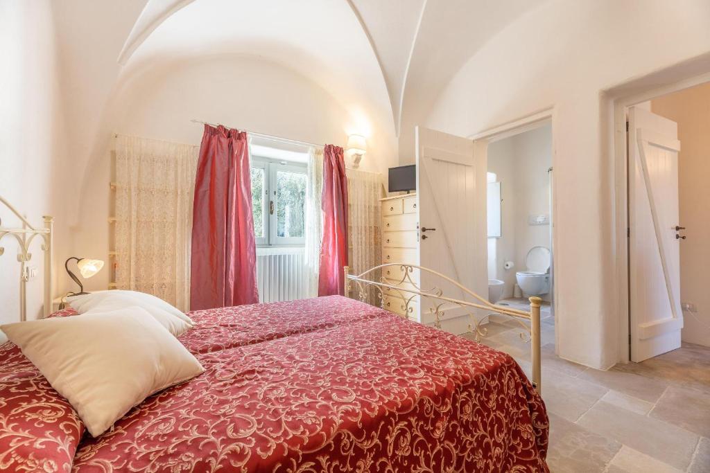 une chambre avec un lit avec une couverture rouge dans l'établissement Sentiero della Valle, à Ceglie Messapica