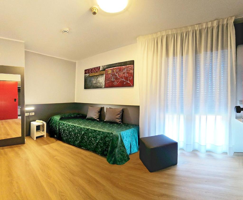 une chambre avec un lit vert et une fenêtre dans l'établissement Hotel Panorama, à Lido di Jesolo