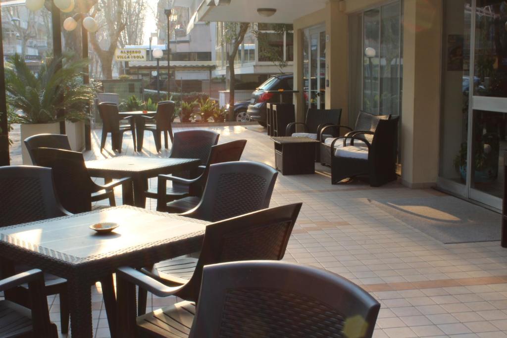 une rangée de tables et de chaises sur une terrasse dans l'établissement Hotel Senyor, à Rimini 64 autres photos