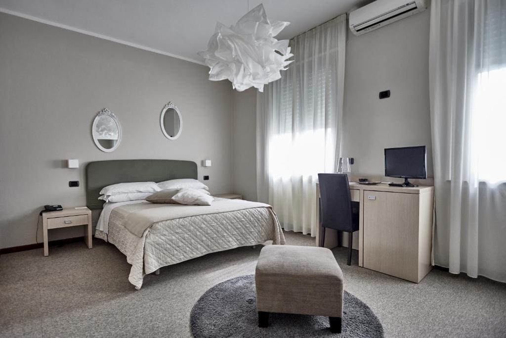 une chambre avec un lit, un bureau et une télévision dans l'établissement Rouge Hotel International, à Milano Marittima
