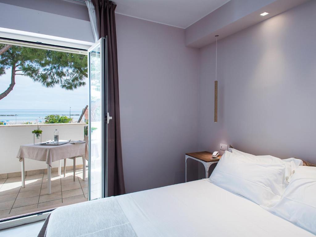 une chambre avec un lit et une vue sur l'océan dans l'établissement Manè Boutique Hotel, à Roseto degli Abruzzi