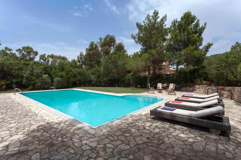 - une piscine avec des chaises longues dans la cour dans l'établissement Sardegna - Villa Con Parco e Piscina a Carloforte, à Carloforte