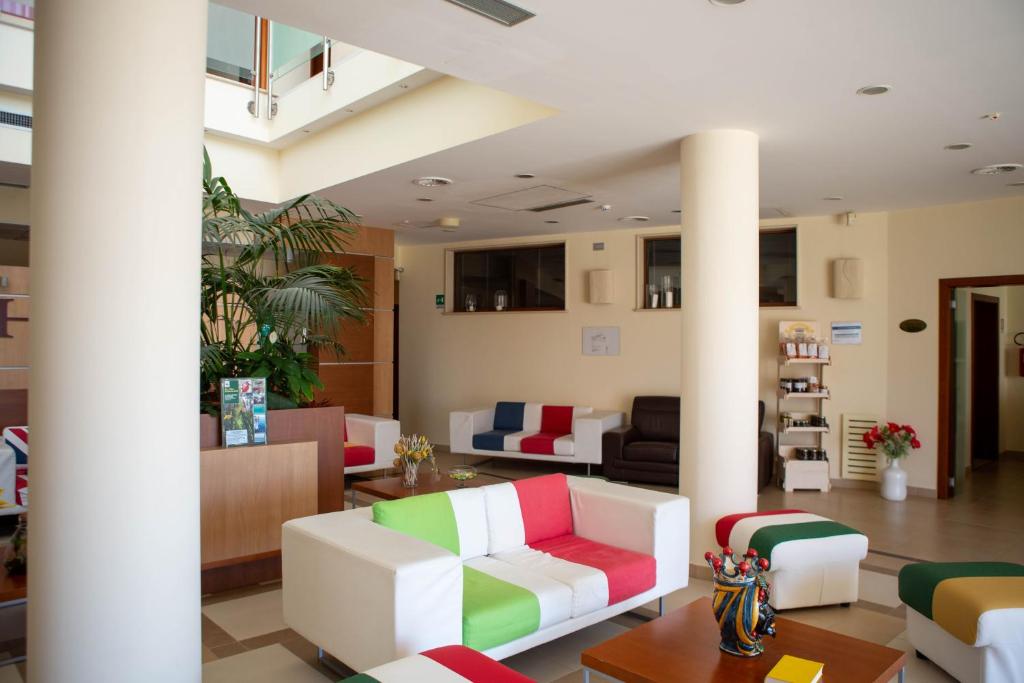 un hall d'entrée avec des canapés et des chaises dans un bâtiment dans l'établissement Hermes Hotel, à Policoro