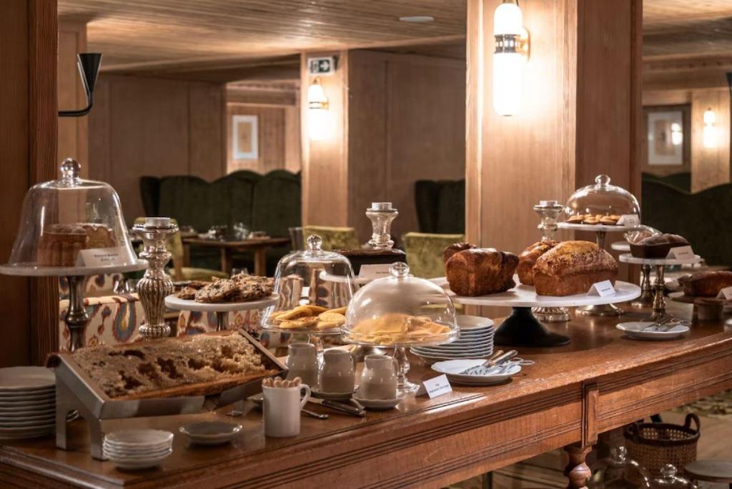 un buffet avec des gâteaux et des pâtisseries sur une table dans l'établissement Alpes Hôtel du Pralong, à Courchevel