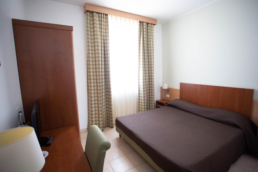 une chambre avec un lit, un bureau et une fenêtre dans l'établissement Hermes Hotel, à Policoro 26 autres photos