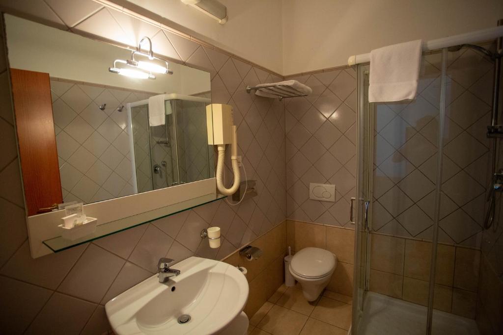 une salle de bain avec un lavabo, une douche et des toilettes dans l'établissement Hermes Hotel, à Policoro