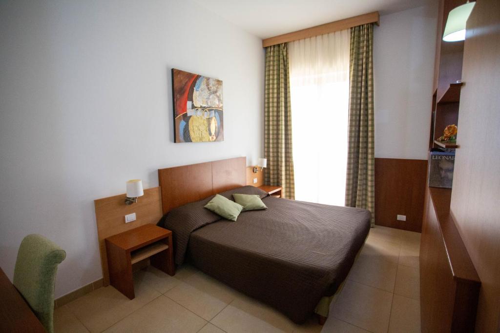 une petite chambre avec un lit et une fenêtre dans l'établissement Hermes Hotel, à Policoro