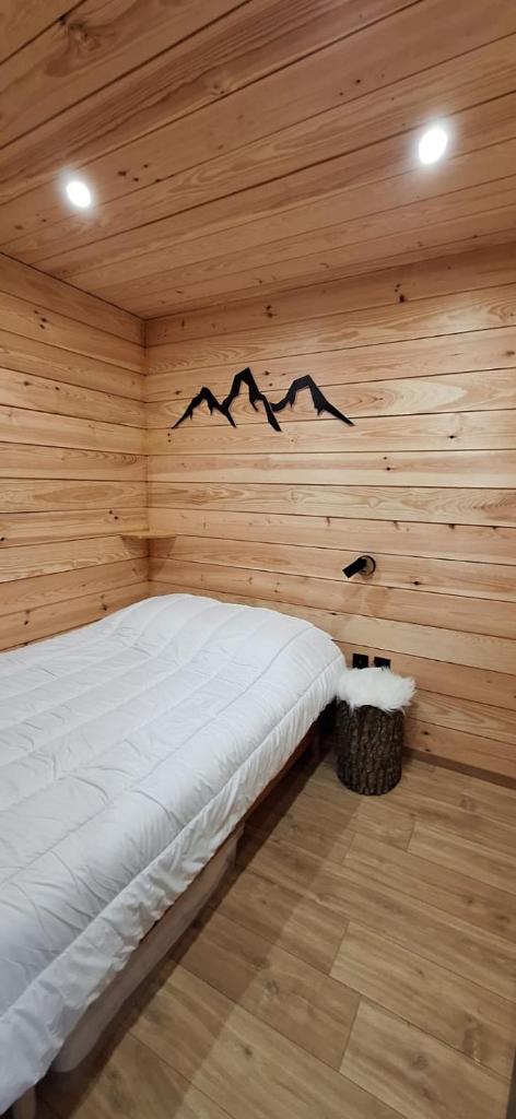 une chambre avec un lit dans une pièce en bois dans l'établissement Appartement chaleureux en cœur de station, à Laruns