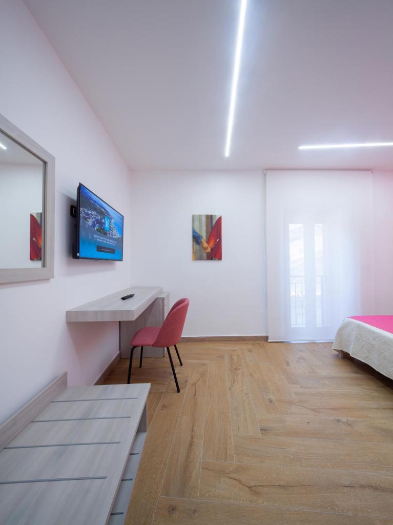 une chambre avec un bureau, un lit et une table dans l'établissement Palazzo Fiorentini Charme Hotel, à Cariati