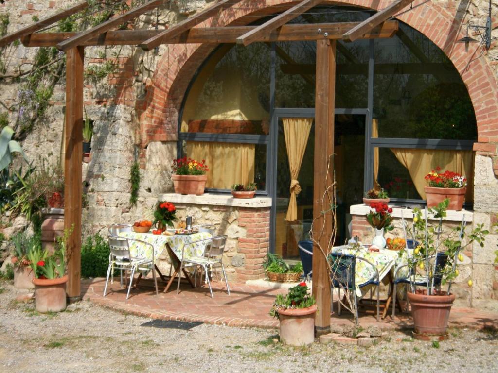 d'une terrasse avec des tables et des chaises dans un bâtiment en briques. dans l'établissement Elegant Villa in Tuscany, à Rapolano Terme