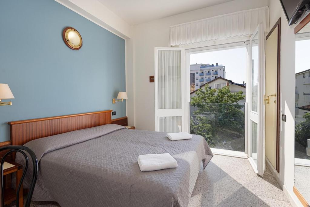 une chambre avec un lit et une grande fenêtre dans l'établissement Hotel Avana Fronte Mare, à Riccione