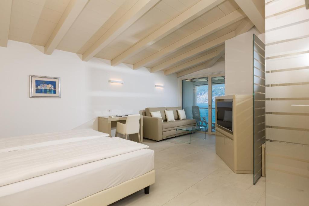 une chambre avec un lit et un salon dans l'établissement Hotel Vega, à Malcesine