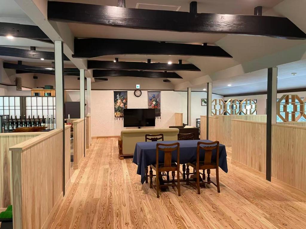 une salle à manger avec une table, des chaises et un canapé dans l'établissement 天然温泉旅館 繁花荘せせらぎ, à Kirishima