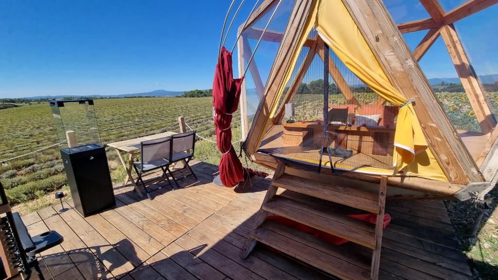 une terrasse en bois avec un gazebo et une scène dans l'établissement La bulle ico, à Valensole