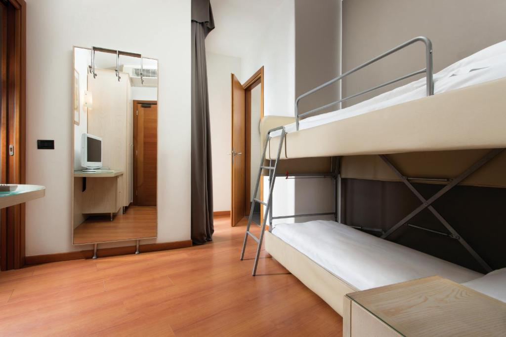une chambre avec deux lits superposés et un miroir dans l'établissement Victoria Frontemare Beach & Spa Hotel Jesolo, à Lido di Jesolo