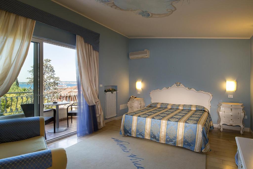 une chambre avec un lit et un balcon avec vue dans l'établissement Hotel Serenella, à Sirmione