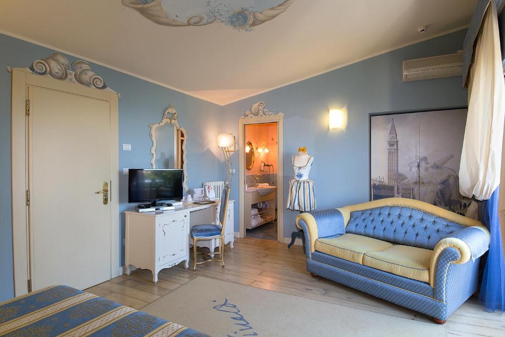 un salon avec un canapé bleu et une télévision dans l'établissement Hotel Serenella, à Sirmione