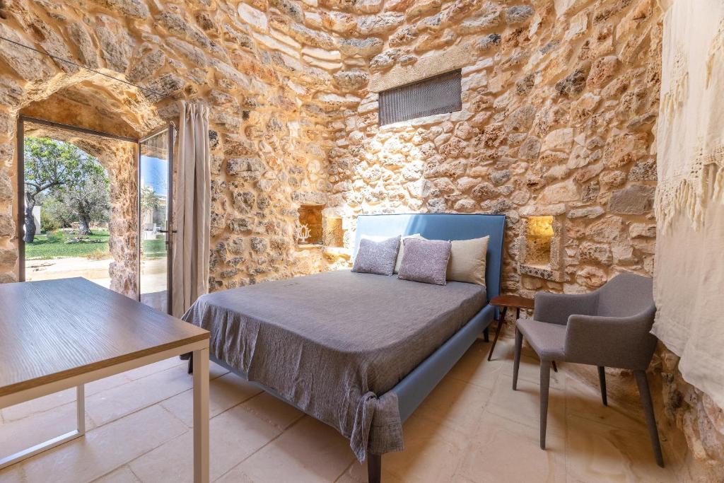 une chambre avec un lit et un mur en pierre dans l'établissement Villa Platino, à Torre Vado