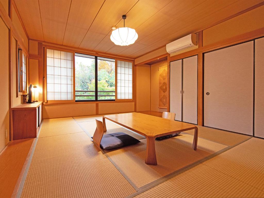 Cette chambre comprend une table en bois. dans l'établissement Yufuin Onsen Ryokan Hananomai, à Yufu