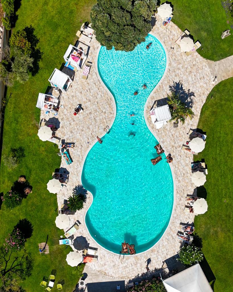 - une vue de tête sur une grande piscine avec des tentes dans l'établissement Hotel San Teodoro, à San Teodoro 158 autres photos
