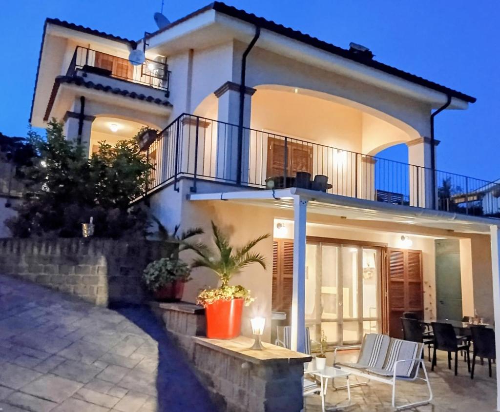 une maison avec une table et des chaises devant dans l'établissement Villa Panorama Pool & Garden, à Trevignano Romano