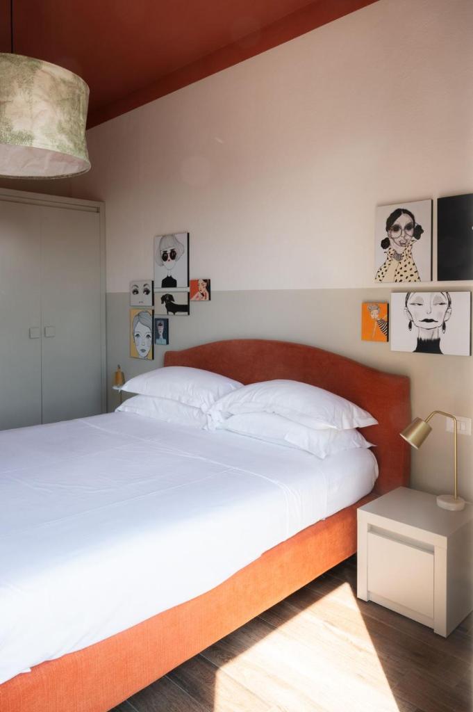 une chambre avec un grand lit avec des draps blancs dans l'établissement Lu. b&b, à Cervia
